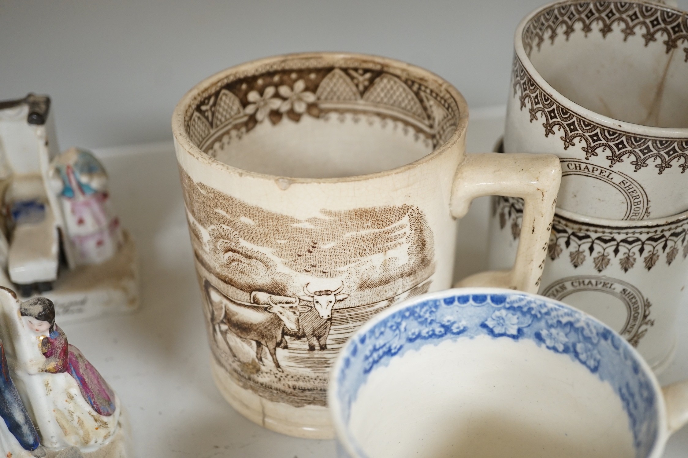 A collection of German porcelain Fairings, including Possneck, and four printed creamware mugs and a cup